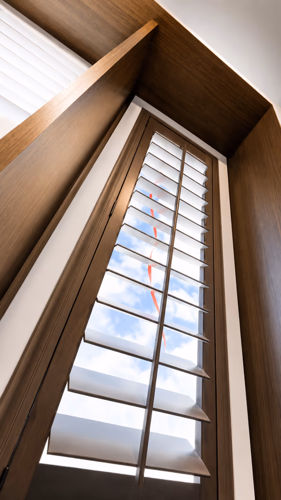 Custom wood plantation shutters fitted to a vaulted, angled triangular window by La Grange Window Coverings in Sonoma County
