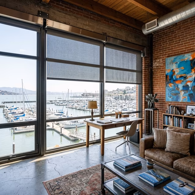 La Grange Window Coverings marine-grade Somfy motorized solar shades with salt-air resistant hardware filtering Richardson Bay light in a Marinship waterfront studio, Sausalito CA 94965